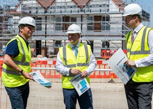 Craig Moule, Nigel Huddleston and Mark Battin in high vis jackets standing in front of the Evesham development.